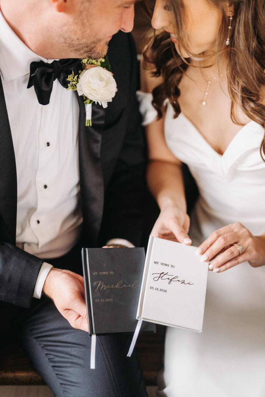 A bride and groom holding their vow books at their wedding