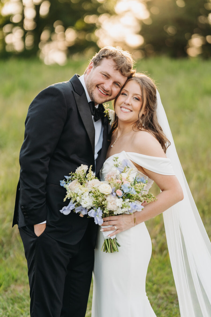 A bride and groom smiling at the camera during golden hour at The Venue at Birchwood
