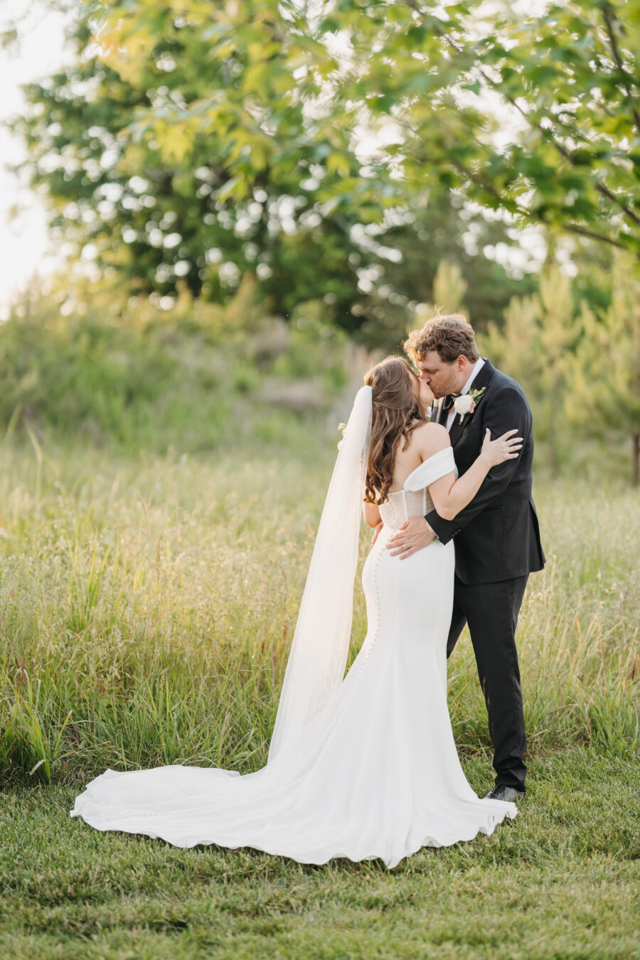 Bride and groom kissing at golden hour during their wedding at The Venue at Birchwood