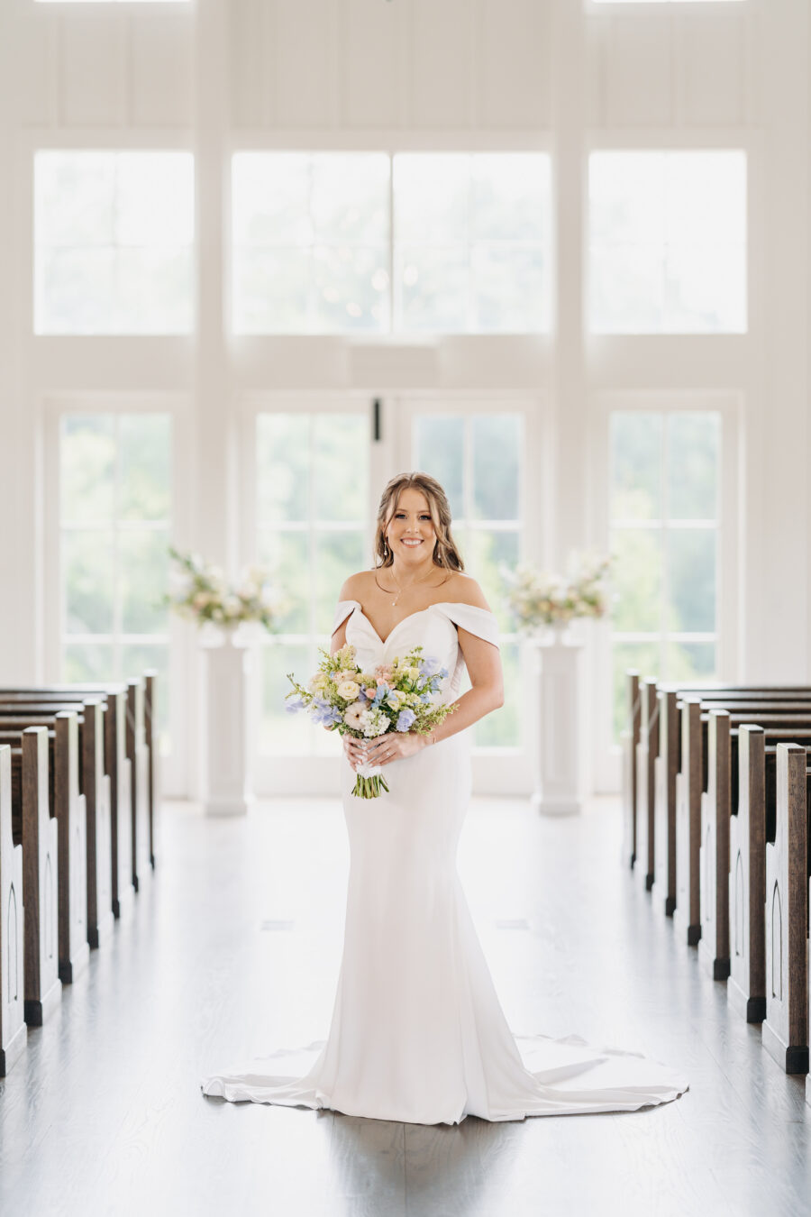 A bride in the aisle at her ceremony at The Venue at Birchwood
